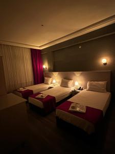 een hotelkamer met 2 bedden en 2 tafels bij Hotel Ferah in Araklı