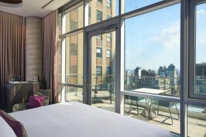 a bedroom with a bed and a large window at Renaissance New York Midtown Hotel in New York +57 photos