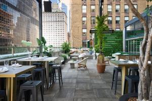 a restaurant with tables and chairs on a balcony at Renaissance New York Midtown Hotel in New York