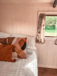 a bedroom with a bed with a window and a pillow at The Hideaway in Fakenham