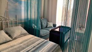 a bedroom with a bed and a chair next to a window at GREEN LAGOON in Calpe +42 photos