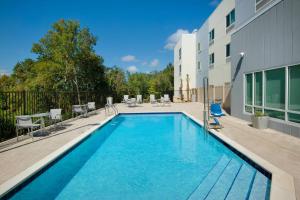 a swimming pool with chairs and a building at TownePlace Suites by Marriott Niceville Eglin AFB Area in Niceville