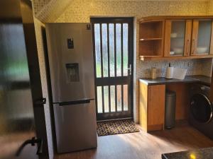 eine Küche mit einer Tür, die sich zu einer Küche mit einer Theke öffnet in der Unterkunft Travel host in Nitshill