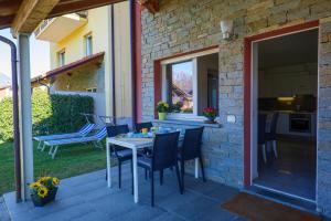 eine Terrasse mit einem Tisch und Stühlen sowie eine Küche in der Unterkunft Residence Girasole Casa Rossa A in Colico