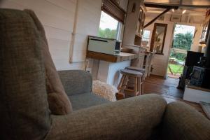 sala de estar con sofá y chimenea en Shepherds Hut in enclosed field en Cardiff