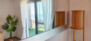 a staircase leading to a window with a view of the ocean at Apartamento Jardines de Deveses by DENIA COSTA in Denia +56 photos