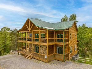 Cabaña de madera grande con techo verde en Sunset Peak, en Sevierville