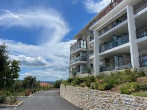 un edificio de apartamentos al lado de una carretera en L'écrin des Oliviers en Grasse