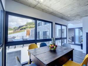 uma sala de jantar com uma mesa com uma taça de fruta em Villa do Espigao by Atlantic Holiday em Fajã da Ovelha