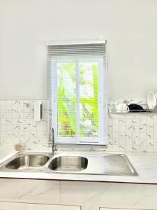 a white kitchen with a sink and a window at Lay Back Villa C4 Kitchen & High Speed Internet in Ban Nong Thale