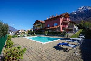 una villa con piscina e una casa di Residence Girasole Casa Rossa B a Colico