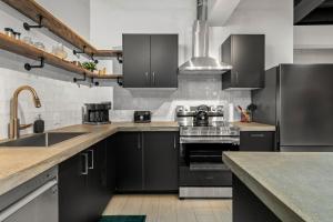 a kitchen with black cabinets and stainless steel appliances at The Goodman: Front Street Flats in Belleville