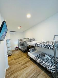 um quarto com 3 beliches e uma televisão de ecrã plano em HOSTEL COSTA-LUZ Béjar em Huelva