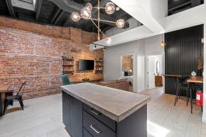 an open kitchen and living room with a brick wall at The Goodman: Front Street Flats in Belleville
