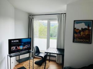 uma sala de estar com uma mesa e uma janela em Luxembourg City - 70m2 - Easy parking - Bus - 2 TVs - between City and Forest em Luxemburgo