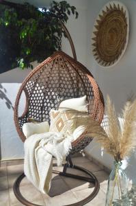 a wicker swing chair with pillows in a room at Casa Hibiscus Marbella in Marbella