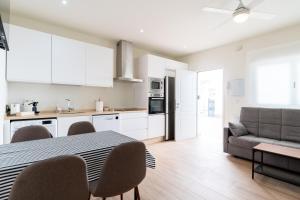 a kitchen and living room with a table and chairs at Apartamentos Cervantes 17 in Seville
