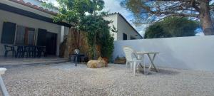 un patio con mesa y sillas junto a una pared blanca en Casa Maria Orosei-Cala Liberotto, en Cala Liberotto