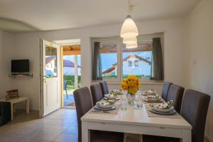 ein Esszimmer mit einem weißen Tisch und Stühlen in der Unterkunft Residence Girasole Casa Gialla in Colico