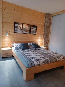 a bedroom with a large bed with a wooden wall at Apartament Bukowy in Zakopane