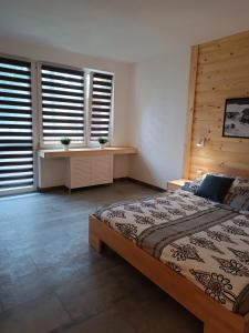 a bedroom with a large bed and two windows at Apartament Bukowy in Zakopane