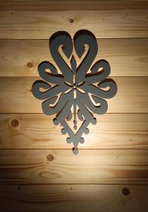 a metal snowflake sign on a wooden wall at Apartament Bukowy in Zakopane