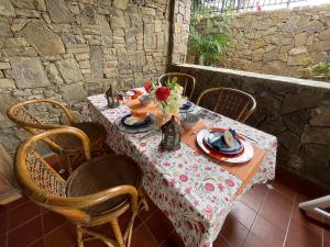L Otro Pueblo Pampatar في Pampatar: طاولة عليها كراسي وطاولة عليها زهور