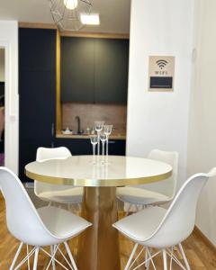 uma sala de jantar com uma mesa branca e cadeiras brancas em Apartment Hera with private garage em Lukavica