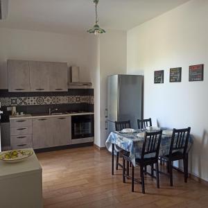 una cucina con tavolo, sedie e frigorifero di Villa Nino a Marina di Ragusa