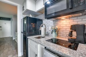 a kitchen with a sink and a black refrigerator at Myrtle Beach Condo with Ocean View and Pool Access! in Myrtle Beach