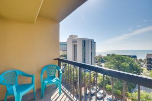 a balcony with two chairs and the ocean in the background at Myrtle Beach Condo with Ocean View and Pool Access! in Myrtle Beach