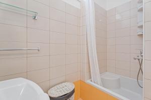 a bathroom with a shower and a toilet and a tub at Apartments Dante in Podstrana