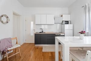 a kitchen with white cabinets and a white table at Apartments Dante in Podstrana