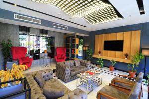a living room with couches and a flat screen tv at Ramada By Wyndham Vakfıkebir in Trabzon