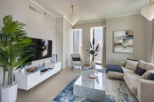 salon z kanapą i telewizorem w obiekcie LARBI Breathtaking Burj and Fountain View Luxurious 2 Bed w Dubaju