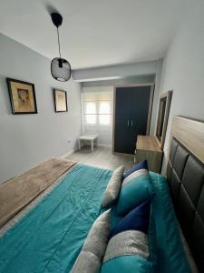 1 dormitorio con 1 cama con edredón verde en Piso Minimalista Reformado en San Vicente de la Barquera