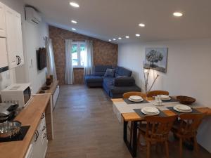 a kitchen and living room with a table and a couch at PLOMIN SKY&BAY in Plomin