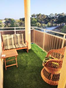 a patio with a couch and chairs on a balcony at Apartament Na Wydmie, garaż + ładowarka EV in Ustka