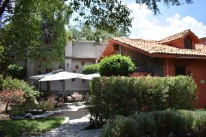 a house with a courtyard with chairs and umbrellas at Casa María Elena in San Miguel de Allende