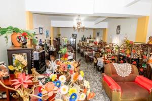 Pousada Oca Porã في كونسيرفاتوريا: غرفة معيشة مليئة بالطاولات والكراسي