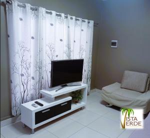 a living room with a tv and a chair at Apartamento Vacacional Vista Verde in Tarapoto