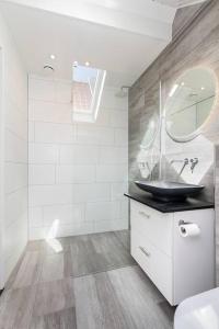 a bathroom with a sink and a mirror at Vakantiehuisje Dichtbij Zee in Vlissingen