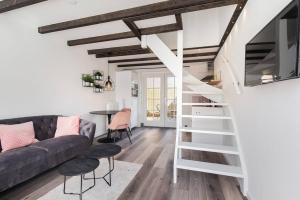 uma sala de estar com um sofá e uma escada em Vakantiehuisje Dichtbij Zee em Vlissingen