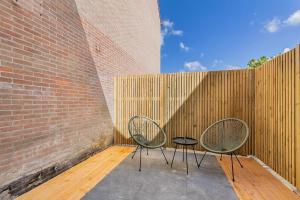 deux chaises assises sur une terrasse à côté d'un mur de briques dans l'établissement Vakantiehuisje Dichtbij Zee, à Flessingue