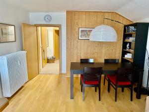 a dining room with a table and chairs and a clock at Dachsteinblick apartment in Ramsau am Dachstein