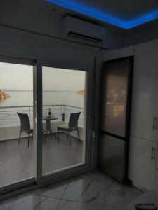 Habitación con balcón con mesa y sillas. en Infinity Blue Suite, en Panteli