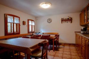 a kitchen with tables and chairs and a clock on the wall at Chalupa Bedřichov in Bedřichov