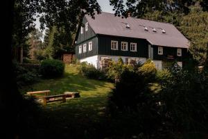a black house with a black roof on a yard at Chalupa Bedřichov in Bedřichov +2 photos