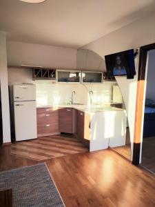 a kitchen with a white refrigerator and a sink at Apartament Na Wydmie, garaż + ładowarka EV in Ustka