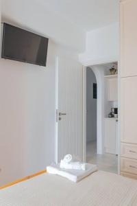 a white bedroom with a bed and a flat screen tv at Martha's filoxenia in Drios